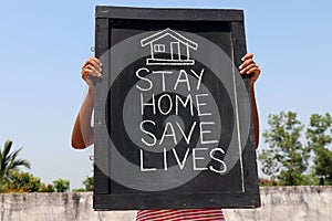 `Stay home save lives` concept written on blackboard.