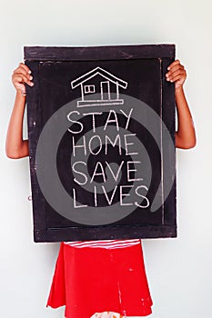 `Stay home save lives` concept written on blackboard.