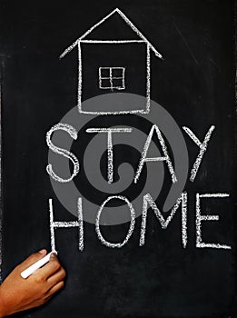 `Stay home`  concept written on blackboard.