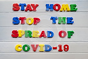 Stay home stop the spread of covid-19  Sign & Symbol, plastic letter on white wood background