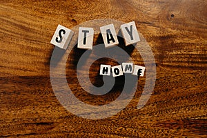 `Stay home` text made of wooden cube on  wooden background