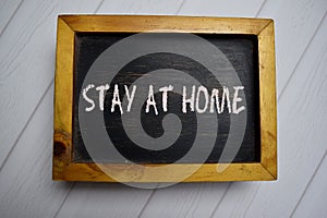 Stay At Home write on a chalkboard isolated on office desk