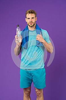 Stay hydrated. Man with towel on shoulders hold bottle. Athlete drink hydration mix with more electrolytes. Hydrates