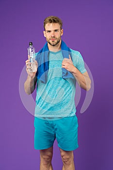 Stay hydrated. Man with towel on shoulders hold bottle. Athlete drink hydration mix with more electrolytes. Hydrates photo