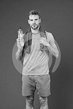 Stay hydrated. Man with towel on shoulders hold bottle. Athlete drink hydration mix with more electrolytes. Hydrates photo