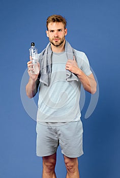 Stay hydrated. Man with towel on shoulders hold bottle. Athlete drink hydration mix with more electrolytes. Hydrates photo