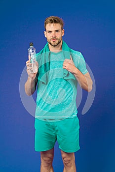 Stay hydrated. Man with towel on shoulders hold bottle. Athlete drink hydration mix with more electrolytes. Hydrates photo