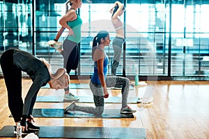 Stay limber. a group of attractive young women stretching before their yoga class begins.