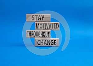 stay motivated throughout change symbol. Concept words stay motivated throughout change on wooden blocks. Beautiful blue