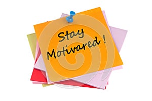 Stay Motivated written on pinned paper close up on white background