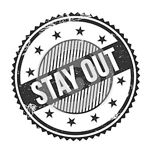STAY OUT text written on black grungy round stamp