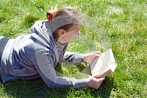 Stay on the plot . Girl reading in the garden