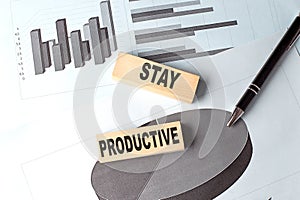 STAY PRODUCTIVE wooden block on chart background