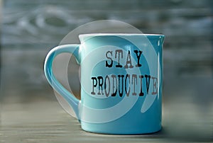 STAY PRODUCTIVE- words on a blue cup on a dark background