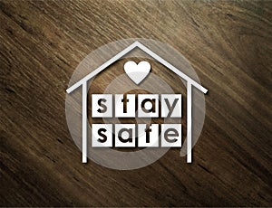 Stay safe. Illustration of white house with text and heart inside on wooden background