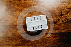 `Stay safe` text in light box on  wooden background