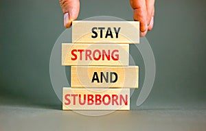 Stay strong and stubborn symbol. Concept words Stay strong and stubborn on wooden block. Beautiful grey table grey background.