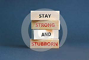 Stay strong and stubborn symbol. Concept words Stay strong and stubborn on wooden block. Beautiful grey table grey background.
