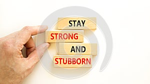 Stay strong and stubborn symbol. Concept words Stay strong and stubborn on wooden block. Beautiful white table white background.