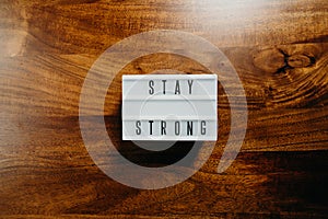 `Stay strong` text in light box on  wooden background