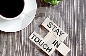 STAY IN TOUCH text on a wooden cubes on a wooden background