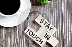 STAY IN TOUCH text on a wooden cubes on a wooden background photo