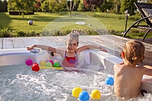 Staycation in summer cottage. Kid having rest in bathtub with bubby water, happy summertime