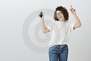 Staying alive with sound of music. Portrait of relaxed joyful good-looking woman in glasses, closing eyes from pleasure