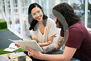 Staying connected as they keep up with trends in the industry. two businesspeople using a digital tablet together in an