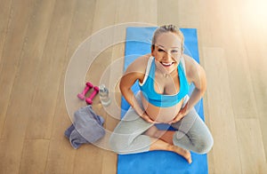 Staying fit for me and for baby. a pregnant woman working out on an exercise mat at home.