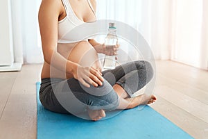 Staying fit right up until her due date. a pregnant woman working out on an exercise mat at home.