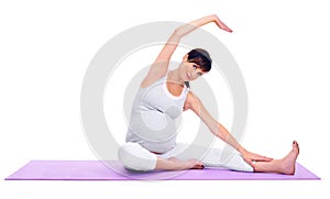 Staying healthy during pregnancy. A pregnant young woman sitting on a pilates mat in the studio.