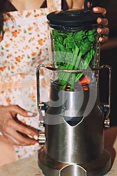 Staying at home woman using electric mixer to prepare vegetarian food