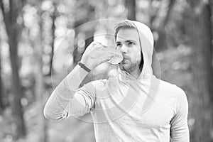 Staying hydrated. Athlete drink water after training in park. care body hydration. sport and health. man in hood drink