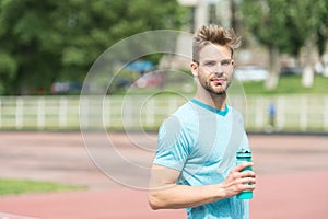 Staying hydrated. Man athletic appearance holds water bottle keep staying hydrated during training. Guy sport clothes