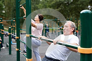 Staying after retirement. Happy joyful mature retired sportsman wearing sportswear doing side stretching exercises with