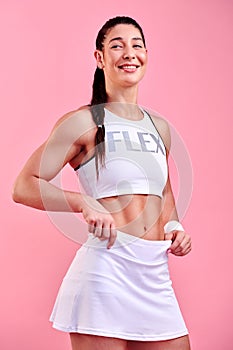 Staying in tiptop shape. Studio shot of a sporty young woman posing against a pink background.