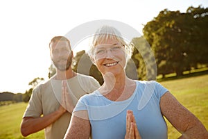 Staying young at heart through yoga. Portrait of a happy mature couple doing yoga together outdoors.