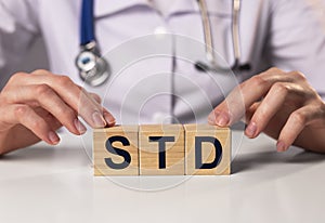 STD acronym inscription on wooden cubes in doctor hands