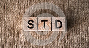 STD - Sexually transmitted diseases, word written on wooden blocks on a brown background