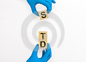 STD, Sexually transmitted infections, acronym text on wooden cubes in doctor gloves over white background