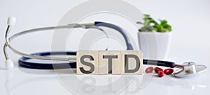 STD the word is written on the wooden cubes and sthetoscope and piils . Medical concept