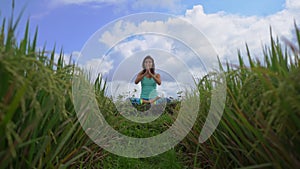 Steadicam shot of a young woman doing meditation for Muladhara chakra in a Balinese way