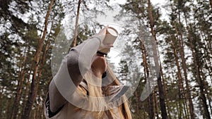 Steadycam fly around shot. Woman drink coffee in the pine forest