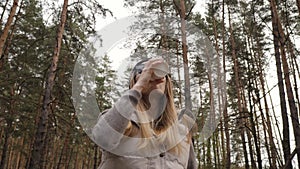 Steadycam fly around shot. Woman drink coffee in the pine forest