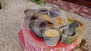 Steadycam shot of collection of tropical cooking spices in stone bowls