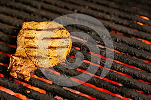 Steak cooking over flaming grill