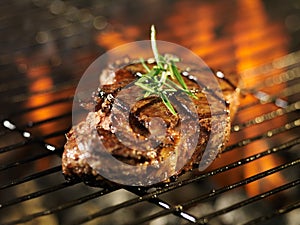 Steak cooking over flaming grill