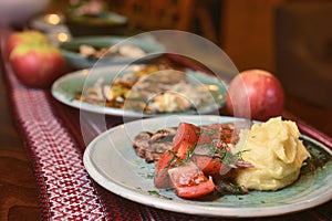 Steak dinner with garlic mashed potatoes and sauteed vegetables served in a ceramic plate over rustic wooden table