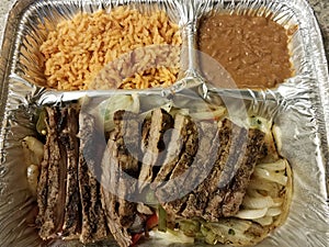 Steak fajita meat with rice and beans in metal container